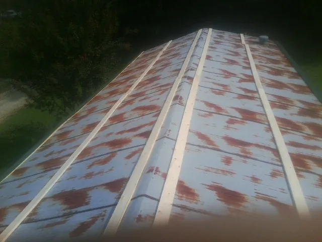Rusted metal roof panels with new wood purlins before replacement — Storm Damage Roof Repair in Johnston by Roofing Brothers