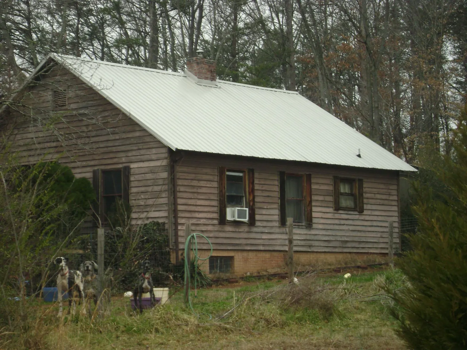 White metal roof on an old wood sided farmhouse, from a Metal Roof Installation job in Johnston
